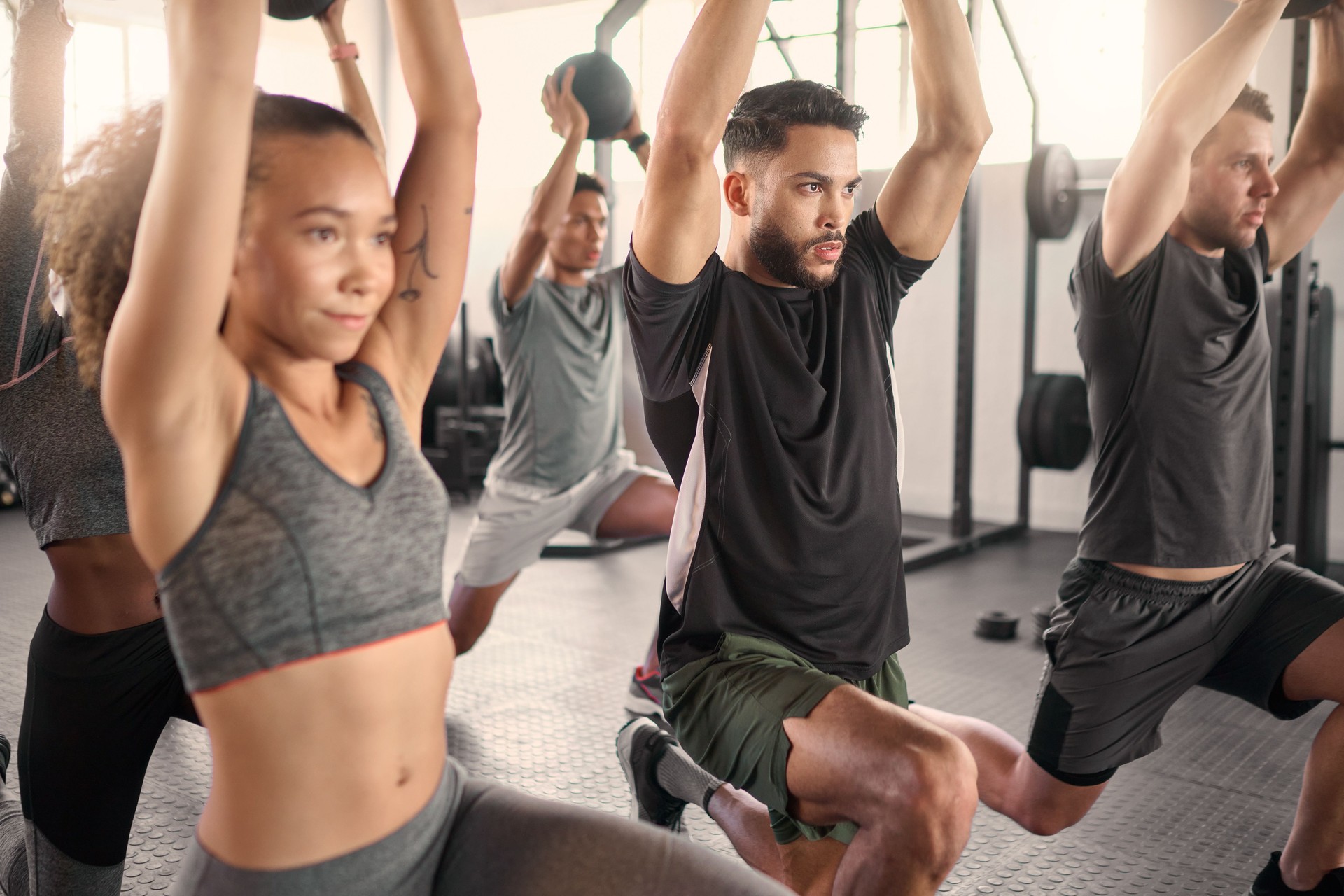 Workout class, fitness and training in a gym with diversity doing health exercise with balance. Athlete, wellness and sports group or cardio friends doing a strong muscle challenge with power